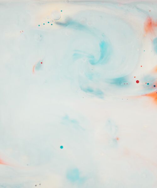 Abstraktes Muster aus sanften Blau- und Orangetönen, die sich wirbelnd auf einer hellen Fläche vermischen.