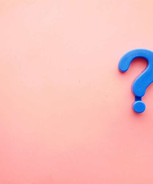 Blaues Fragezeichen auf rosa Hintergrund, Symbol für Neugier, Fragen oder Informationssuche.