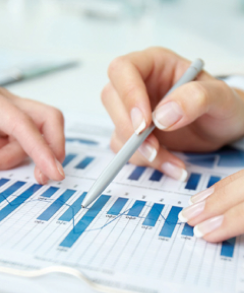 Zwei Hände zeigen mit einem Stift auf ein Diagramm mit blauen Balken und Linien, Symbol für Analyse und Planung.