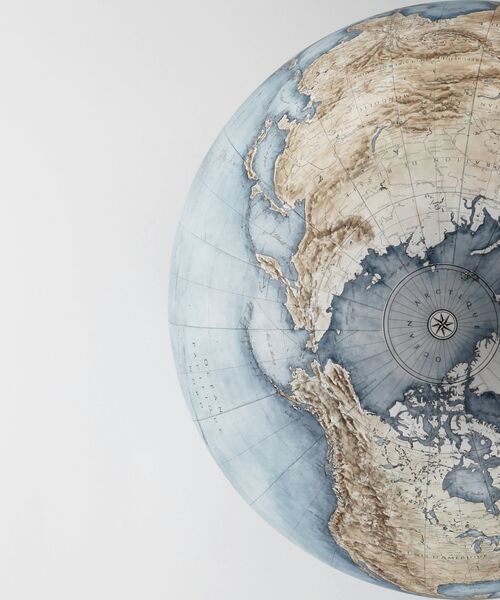 Detailreiche Abbildung eines Globus mit Blick auf die Nordhalbkugel und das Polargebiet.