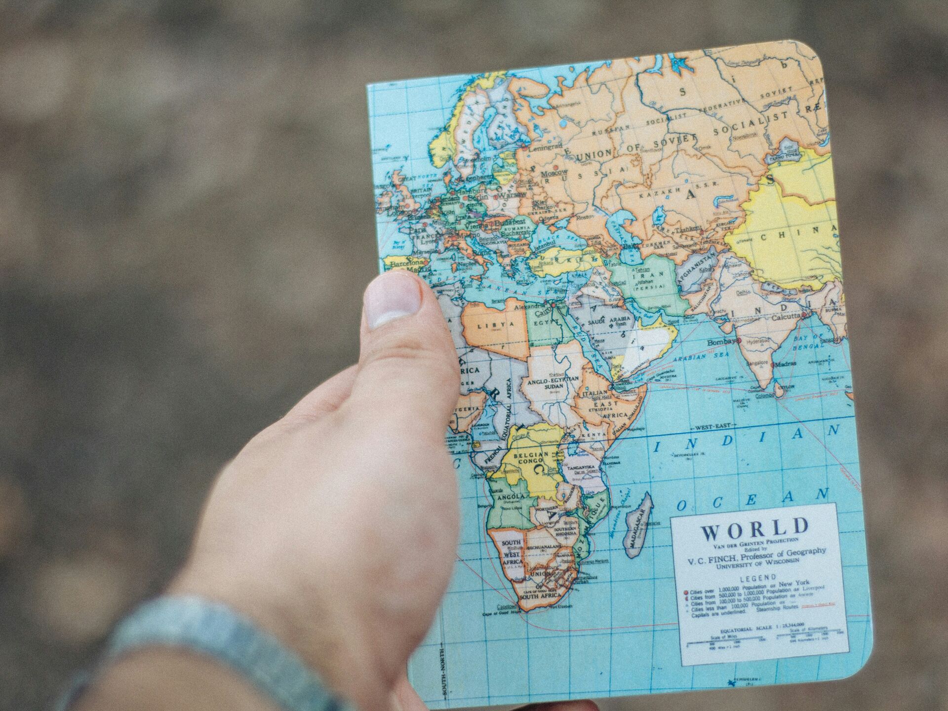 Hand hält eine Weltkarte mit Fokus auf Europa, Afrika und den Nahen Osten.