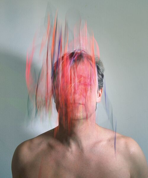 Künstlerisches Porträt einer Person mit abstrakten, farbigen Lichtstreifen, die das Gesicht teilweise verdecken.